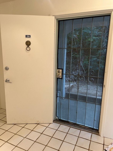 A white door with a glass window and a gold handle.